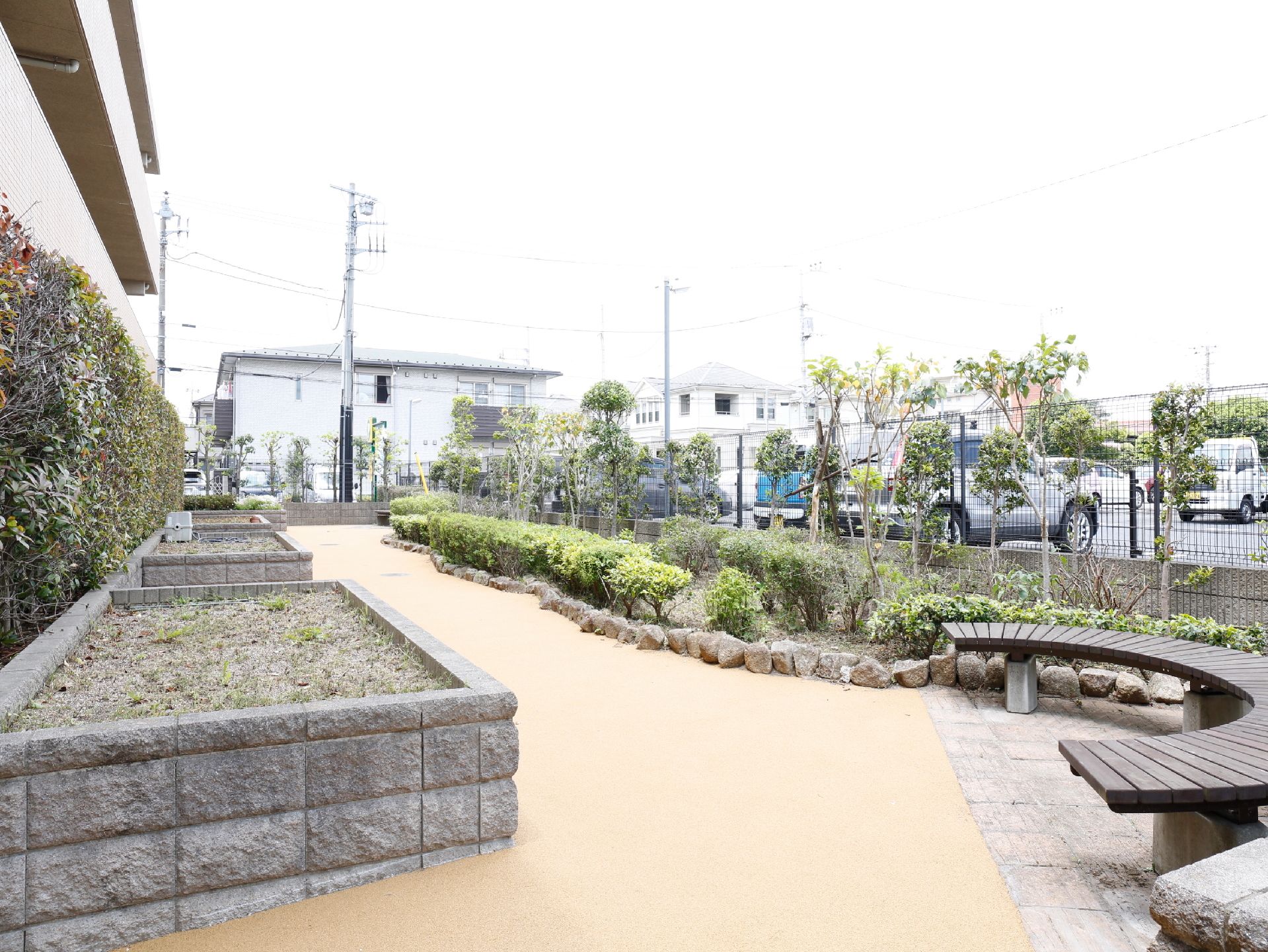 施設の周辺は閑静な住宅地で、緑が多い好環境。建物の周辺は散歩しやすいように整地され、木製のベンチなども置かれている。