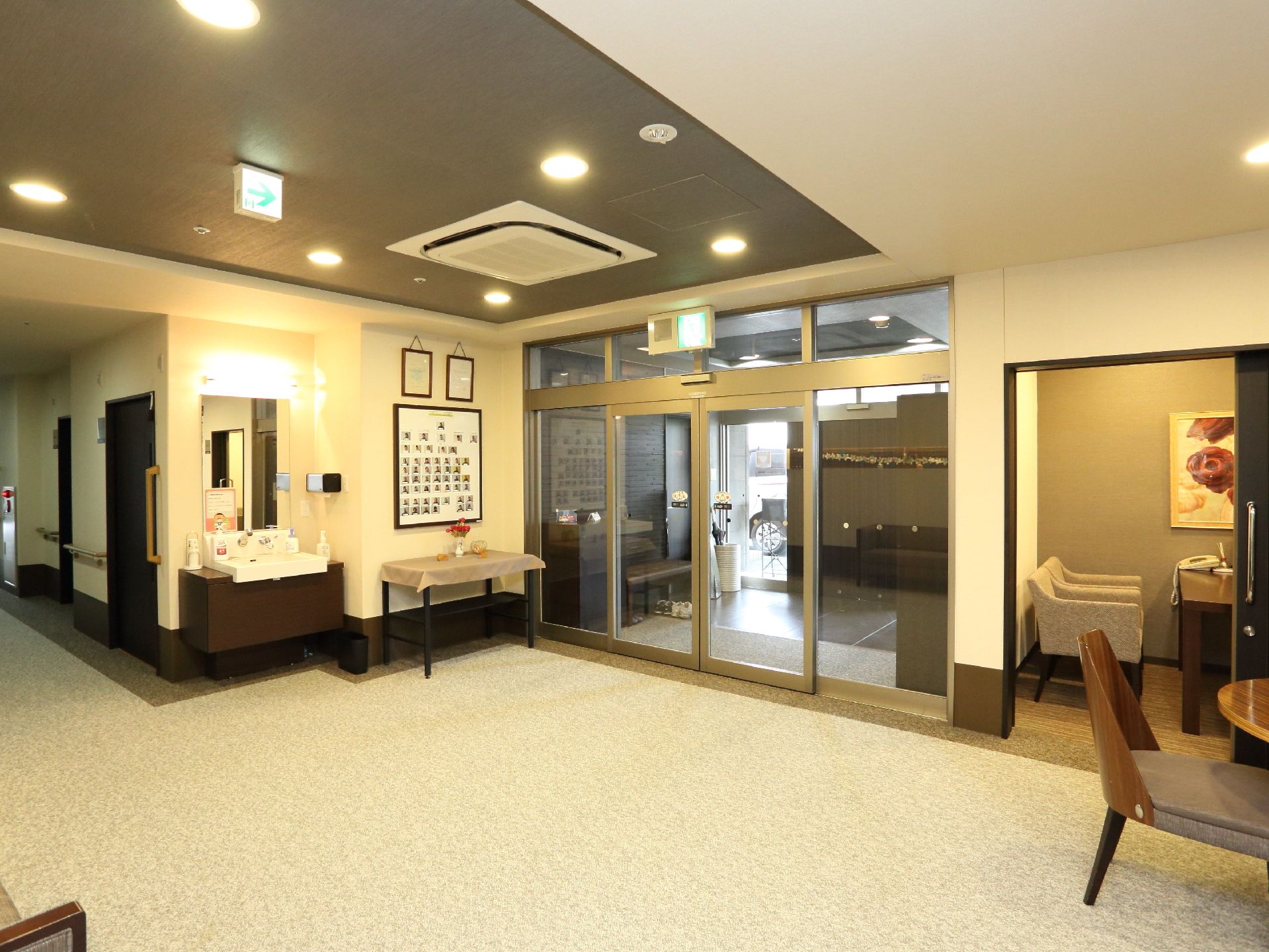 施設の入り口は自動ドア。入り口横に手洗い場が設けられている。床は滑りにくいカーペット敷きになっている。
