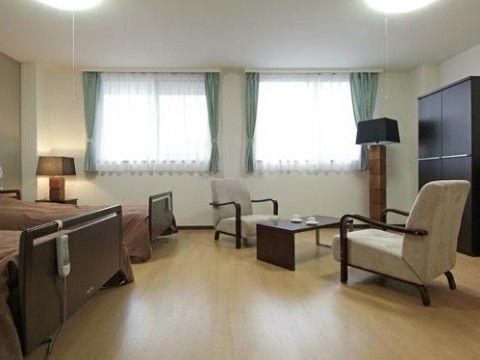 大部屋の一例。ベッドが２台置かれている。ソファが２脚用意されており、テーブルにお茶のセットが出されている。