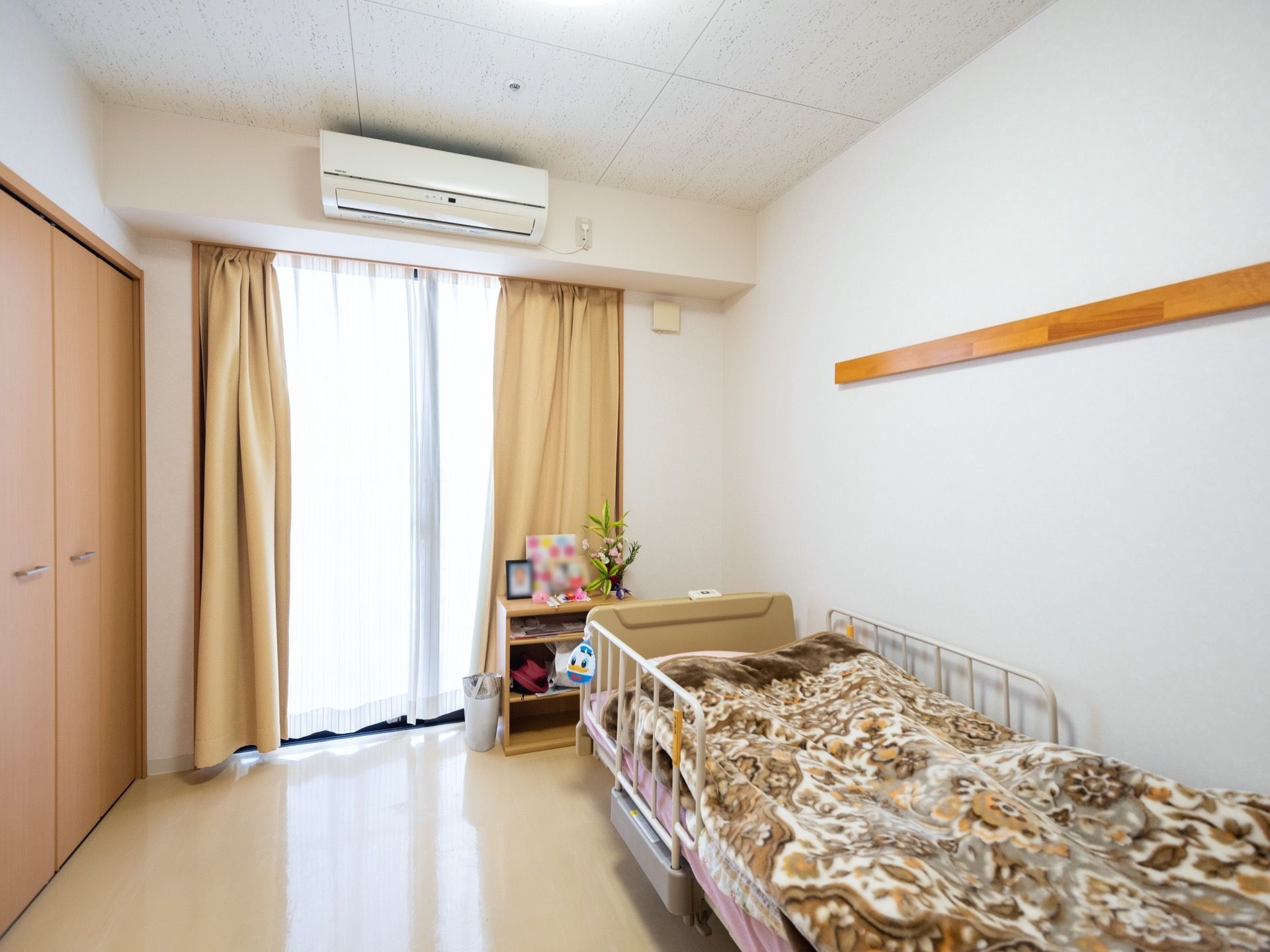 窓にはカーテンが掛けられており、日の光が差し込んでいる。ベッドが設置されており、布団ががある。
