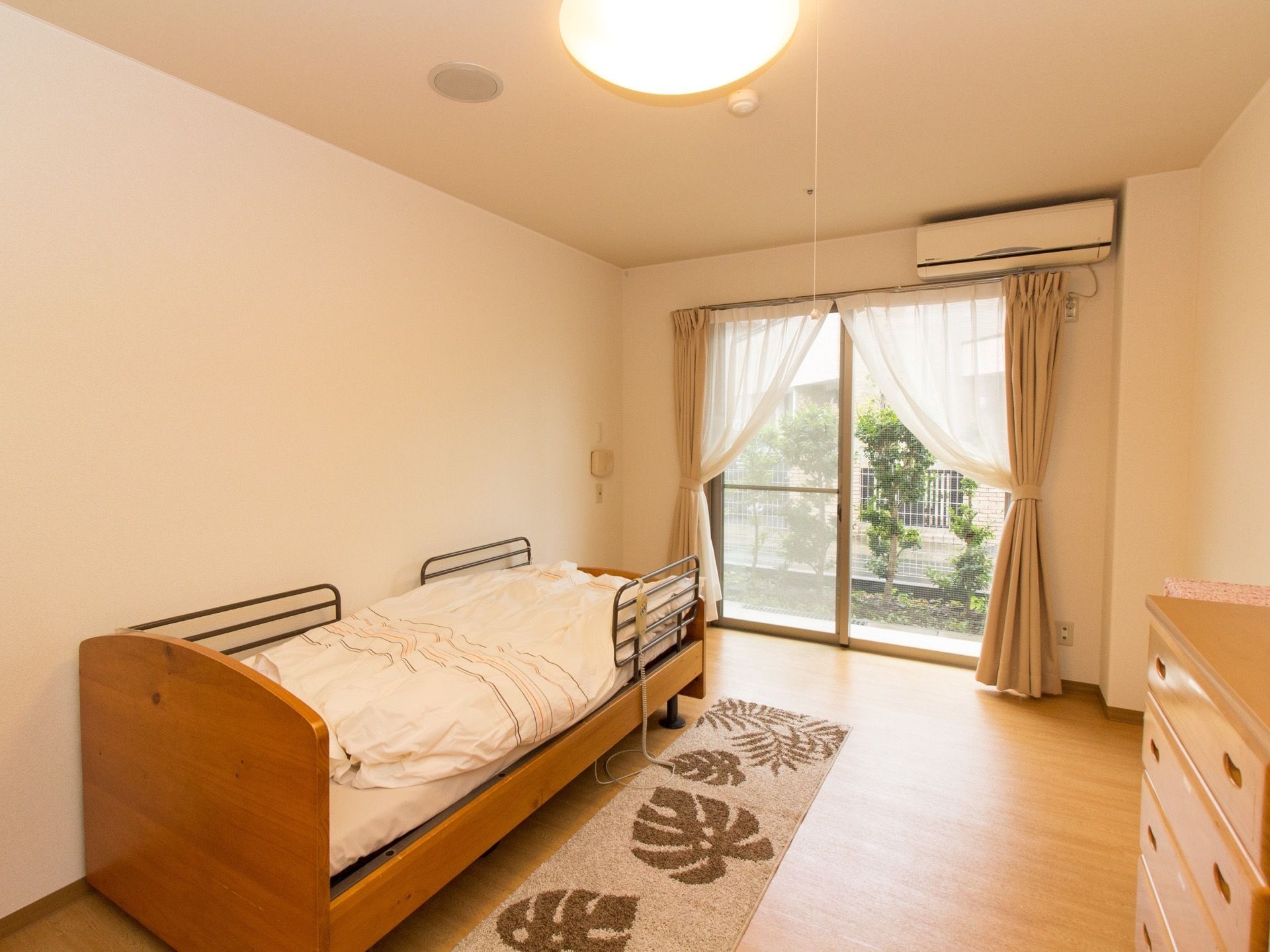日当たり良好で、外の光がたっぷり部屋にはいっている。木製のベッドやチェスト、エアコンなどが完備されている。