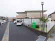 整備された緑地にグリーンの施設看板、外灯が設置されている。まわりには白色のフェンスが備えつけられている。