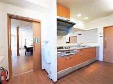 システムキッチンが設置されたキッチンは広く、木目調でおしゃれな雰囲気。