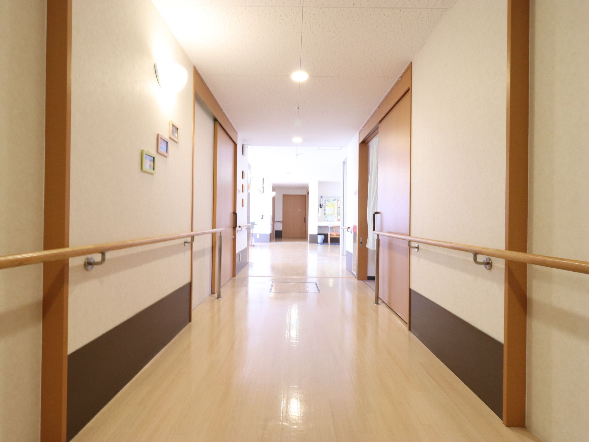 横幅があり広い廊下。両側の壁には手摺が付けられている。壁と天井に照明があり、小さな額縁が飾られている。