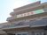 正面入り口の壁には施設名の表示された看板が掛けられている。遠くから見えるように入居者様募集用の大きな垂れ幕が掛けられている。