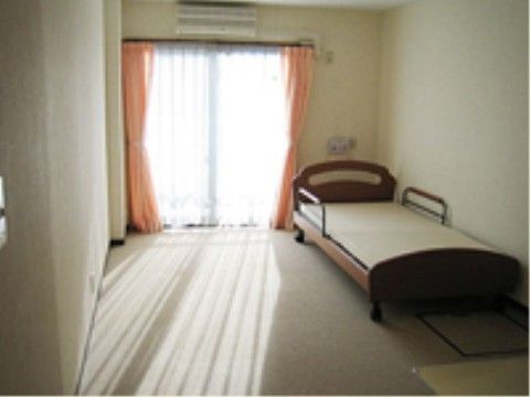 居室のベッドにはタイヤがあり、両サイドにガードが付いている。窓の上にエアコンを設置してあり、好みの室温で生活できる。