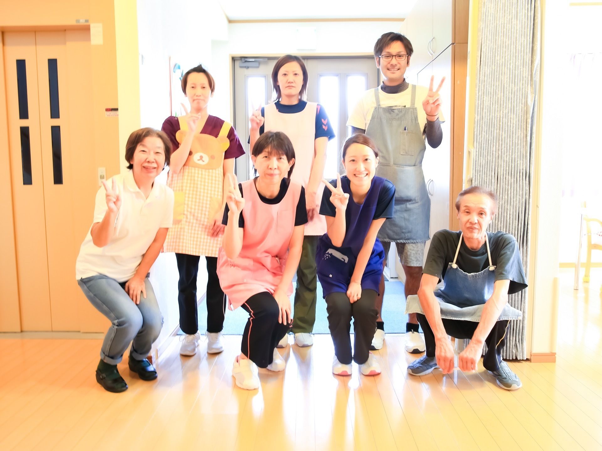 スタッフが７人並んでいる。年齢、性別もさまざまで、それぞれ個性的なエプロンを身に着けている。表情は晴れやかである。