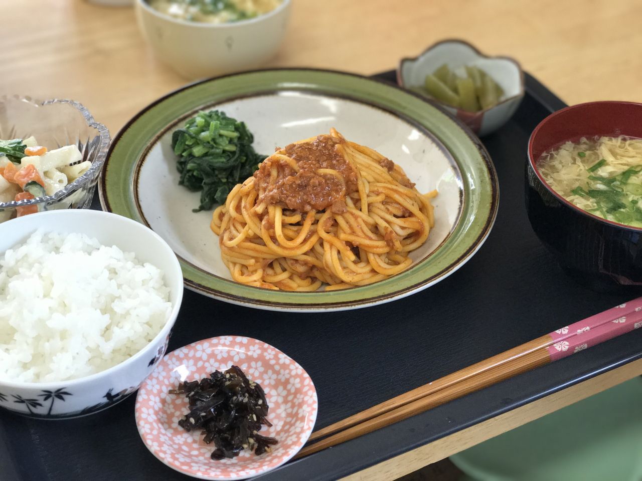 ミートスパゲッティがメインのご飯やかきたま汁と小鉢の付いたメニュー