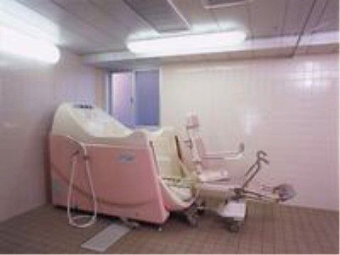 広くて明るい特殊浴室。窓のある壁側に介護入浴機器が設置されている。周りには何もなく充分なスペースが用意されている。