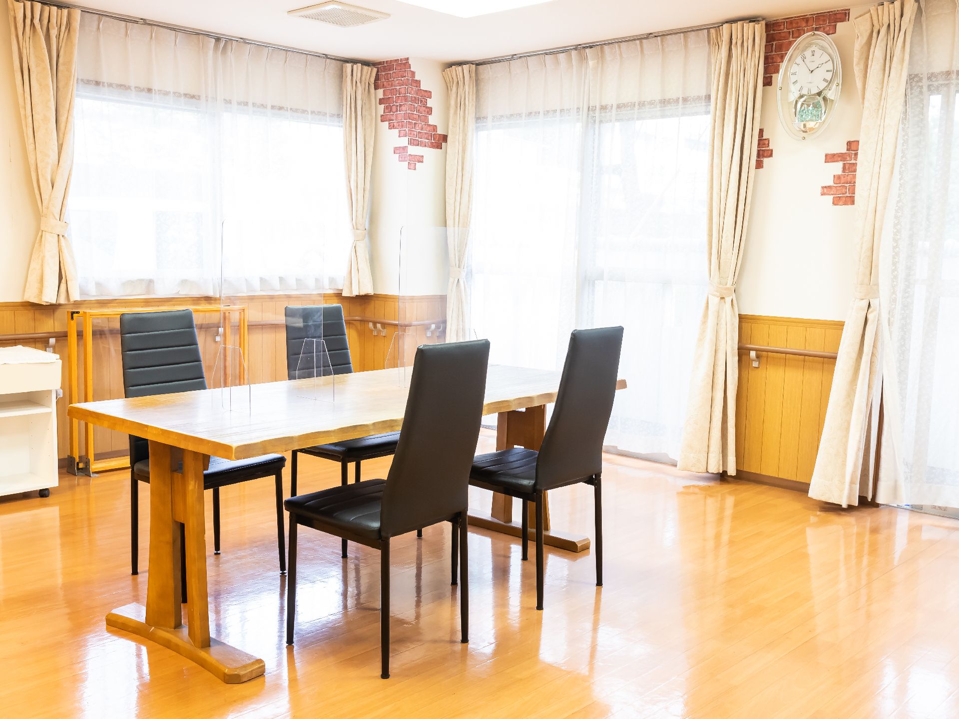 大きな窓から日差しが降り注ぐ椅子とテーブルのある共有スペース