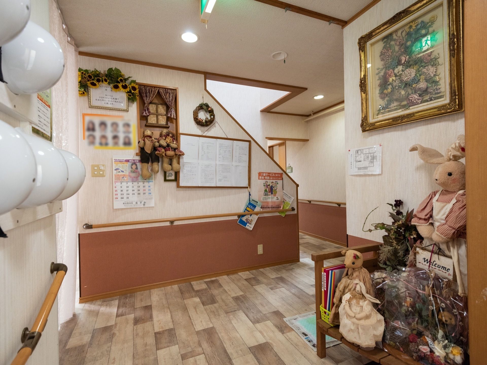 うさぎのぬいぐるみやドライフラワーの飾られた、明るくにぎやかな玄関である。通路には手すりが設けられている。