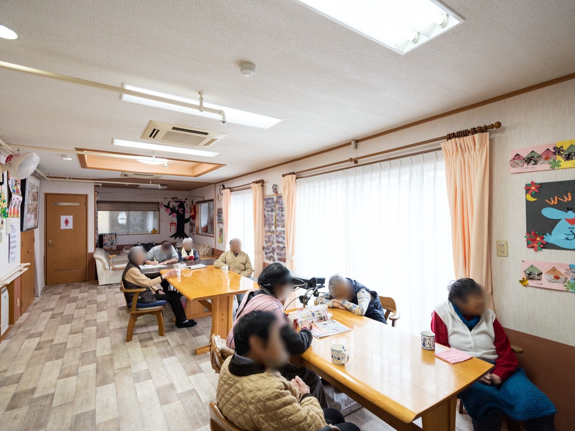 大きな窓から日射しがたっぷりと注いでいる食堂である。広いダイニングテーブルやゆったりと腰掛けられるソファが完備されている。