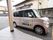 玄関のそばに、施設専用車が停められている。フロントドアに施設名が表示されている。周辺はアスファルトで舗装された平地である。