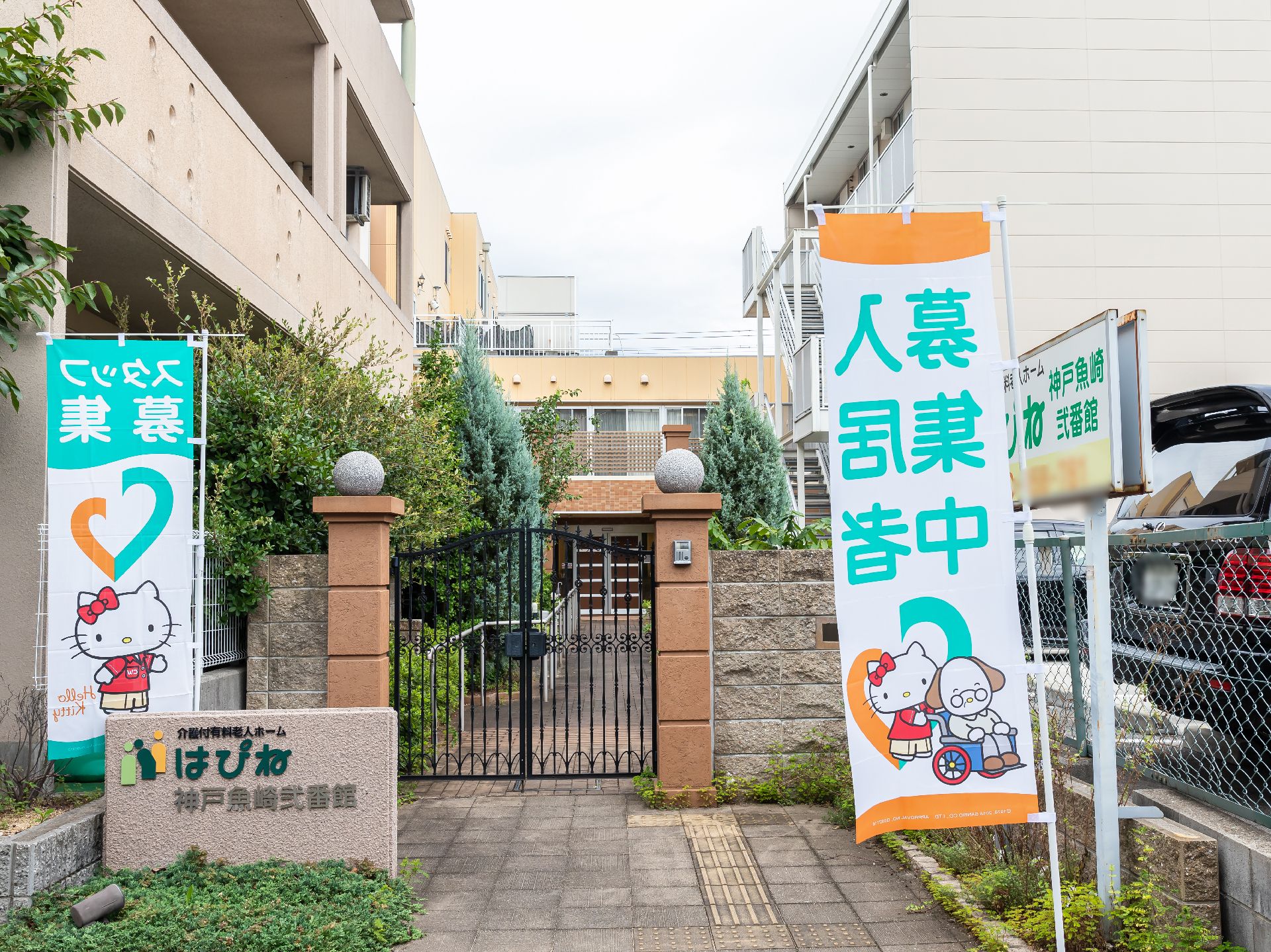 施設の名称が記載されている旗とオブジェクトが設置されている玄関