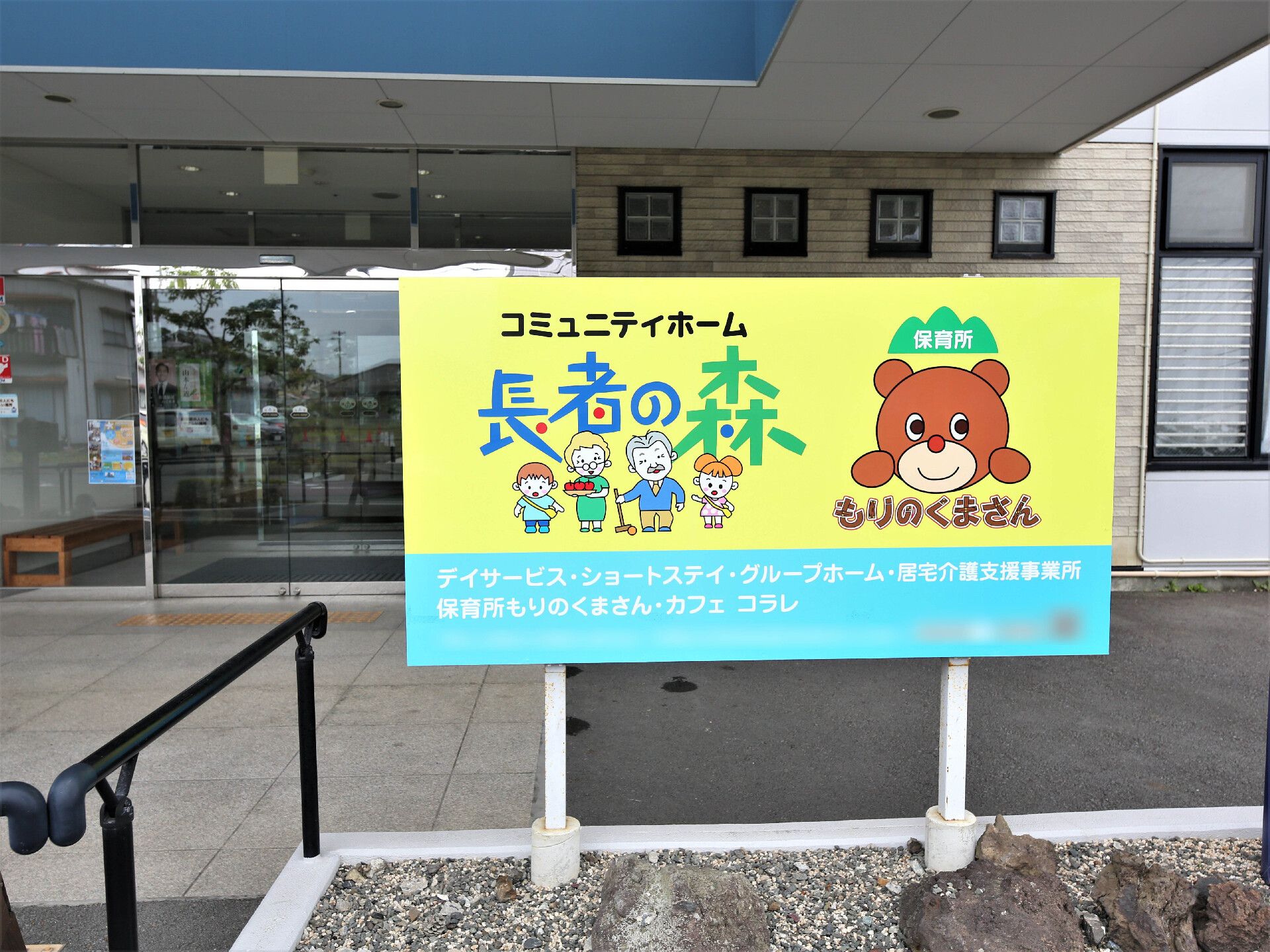 黄色と水色の背景にくまの絵が描かれている施設の看板