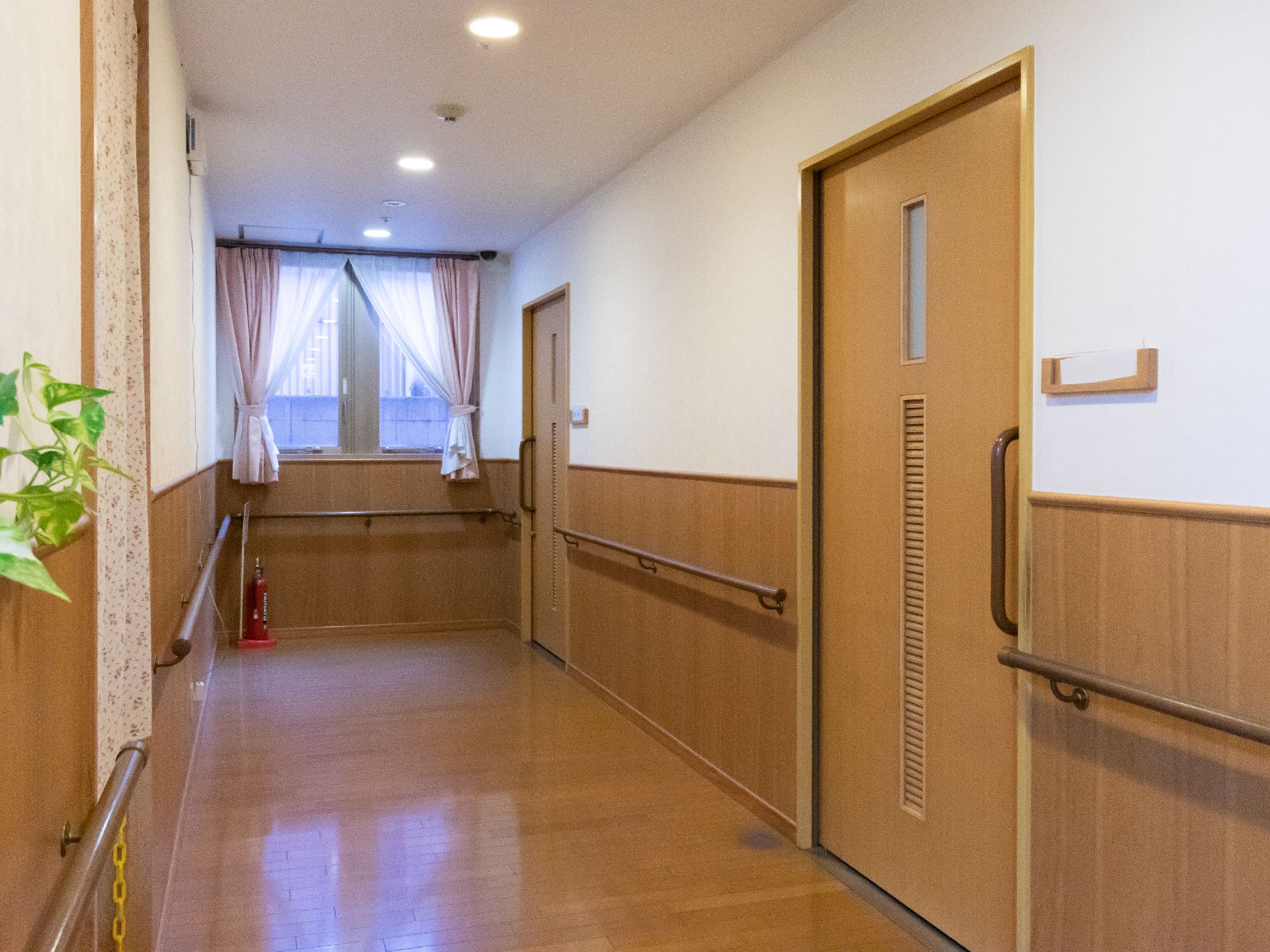 日差しが差す、手すりが設置された廊下