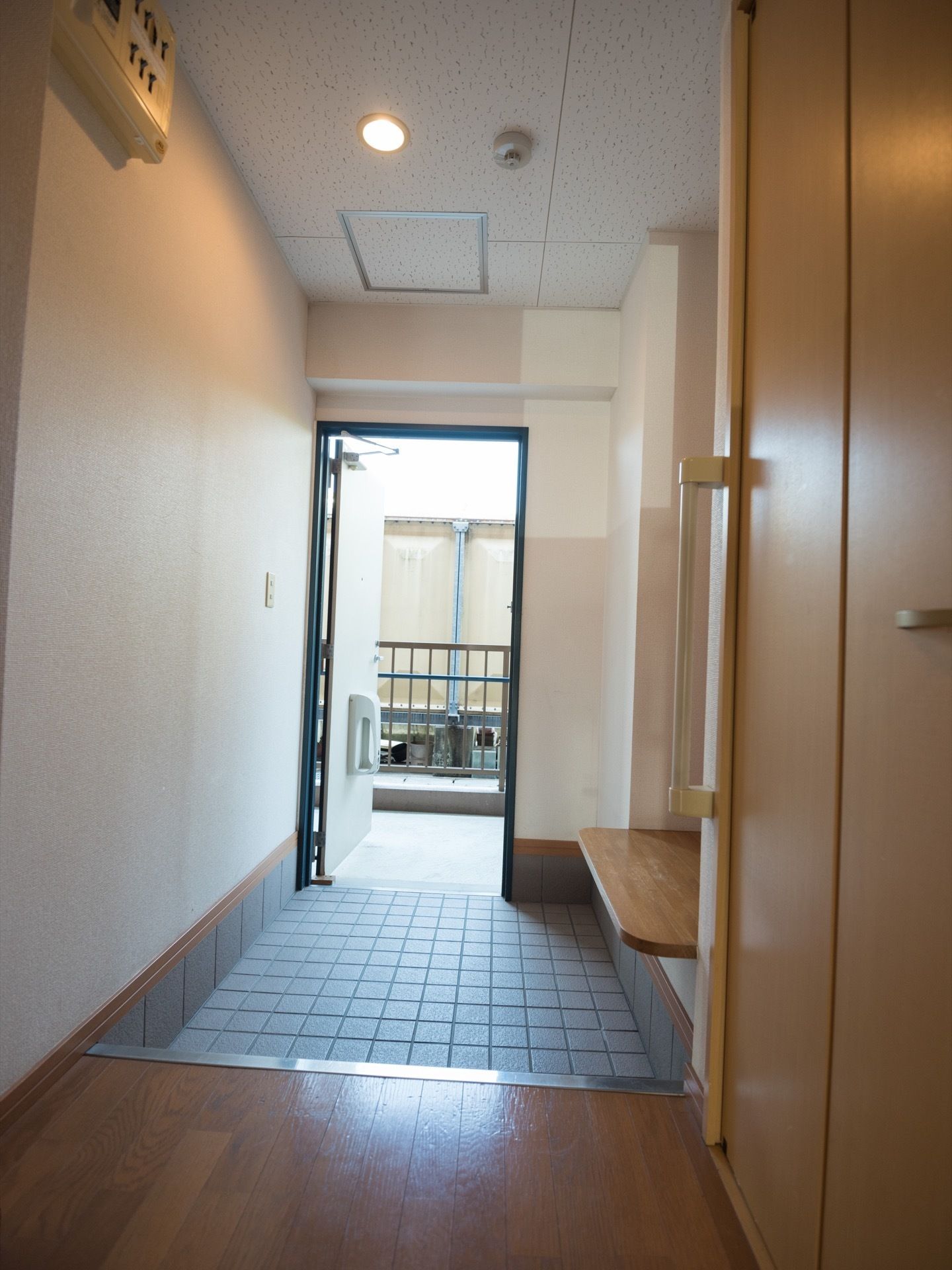 玄関を入ると、土間から廊下は一段上がった造りになっている。腰を下ろせるベンチと収納、手すりが設置されている。