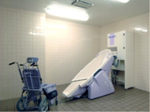 介護用の入浴機器が設置されたタイル張りの浴室
