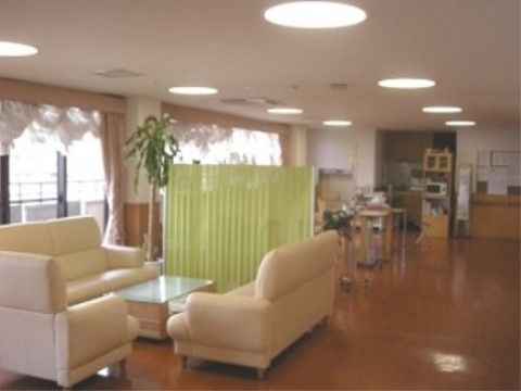 白いソファーが設置され、緑のパーテーションで仕切られた共有スペース