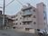 5階建てのモダンな建物。エントランスはまでは緩やかな下りのスロープで手すりが完備されている。安全に歩行ができる。