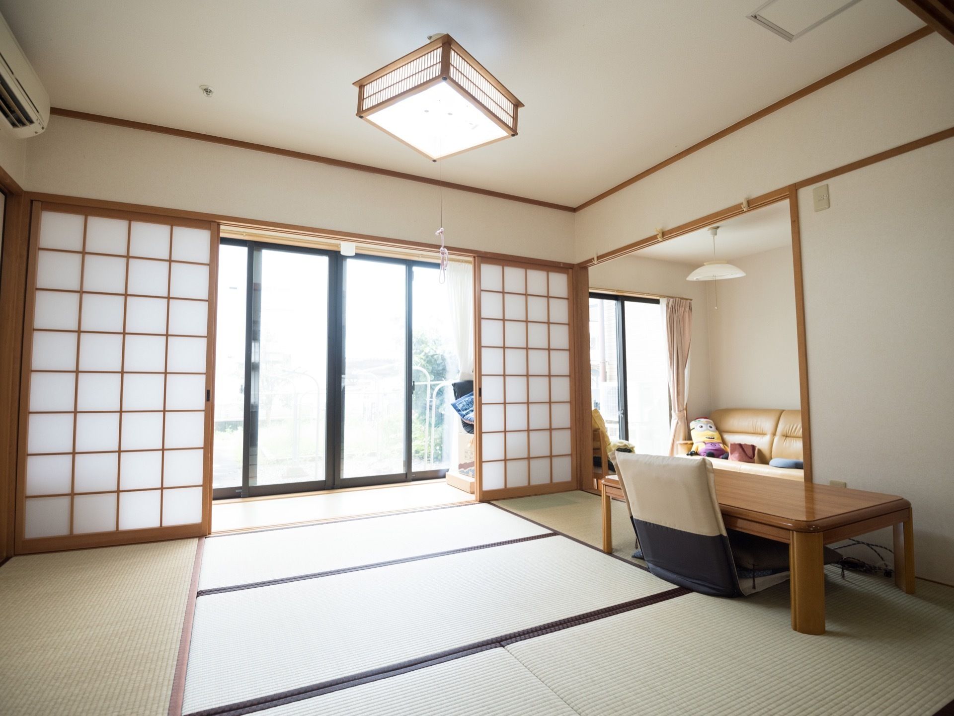 和の落ち着いた雰囲気ただよう一室である。開口部が広々とした、障子戸が備え付けられている。奥には掃き出し窓が見える。