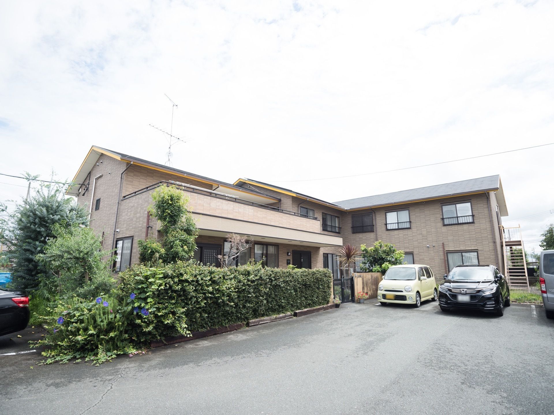 施設はＬ字型で、２階建ての建物となっている。外壁はおしゃれなレンガ調で、周りには植物や木が植えられている。