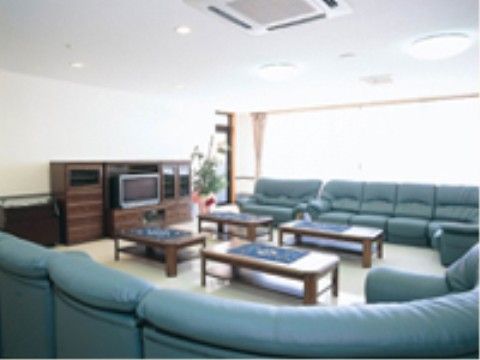 テレビが設置され4つのローテーブルを囲むようにソファーが配置された共有スペース