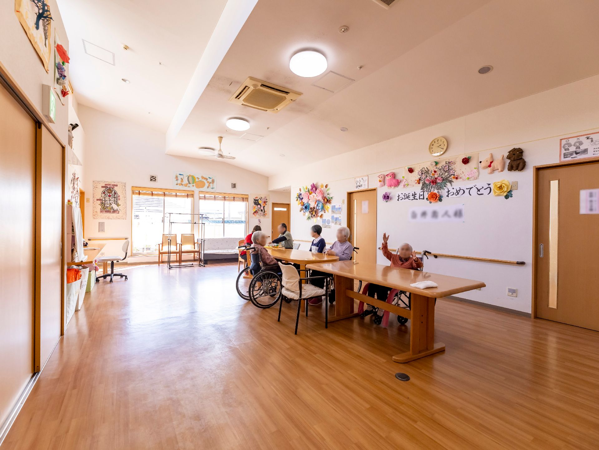 入居者が談笑したりしてくつろいでいる様子のリビングダイニング