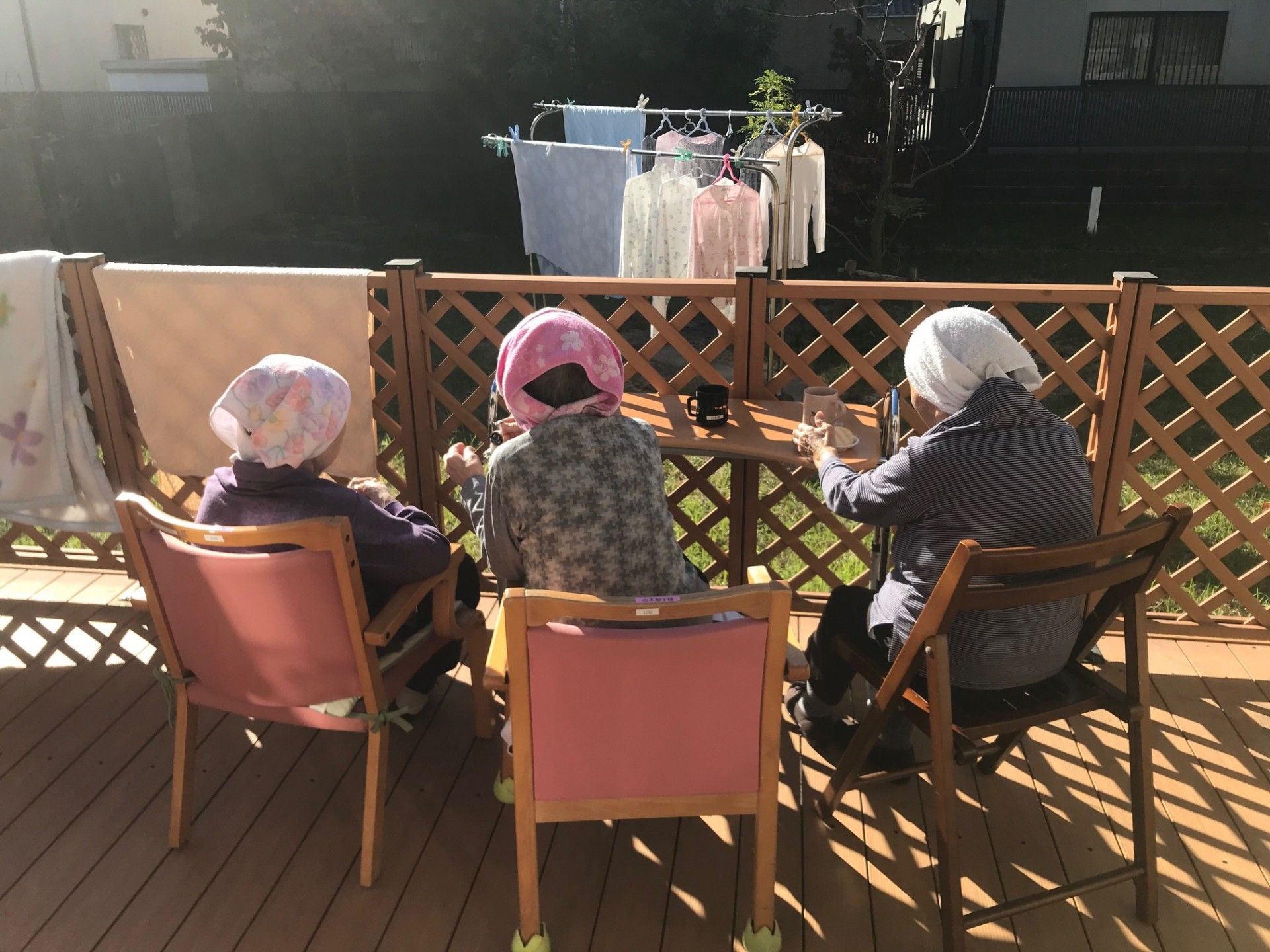 日差しを浴びるテラスでくつろぐ人々