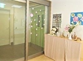 玄関は自動ドアで玄関わきにはぬいぐるみや花などが飾られている。