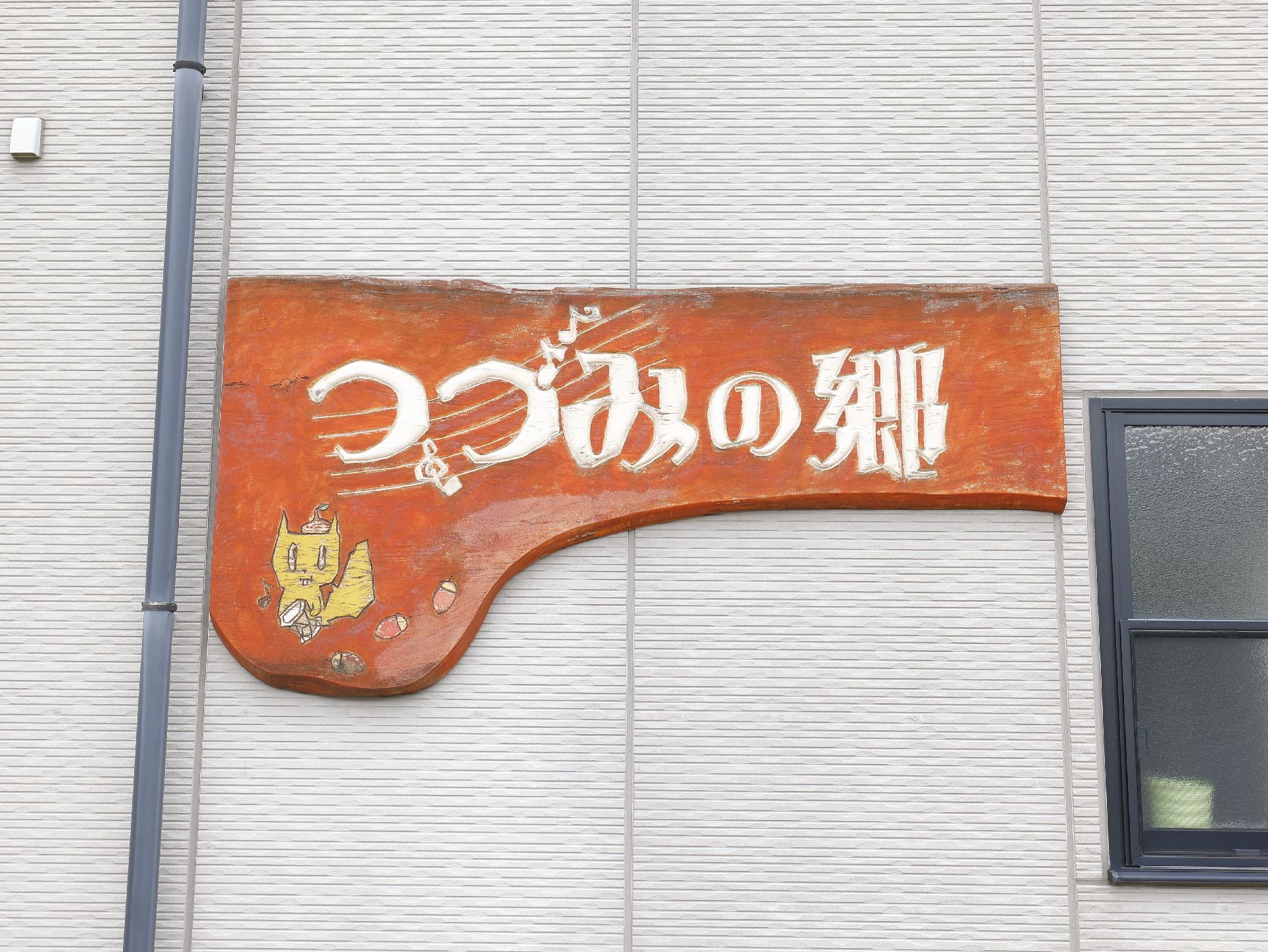 エントランス近くに設置され、施設の名称が書かれている木の看板