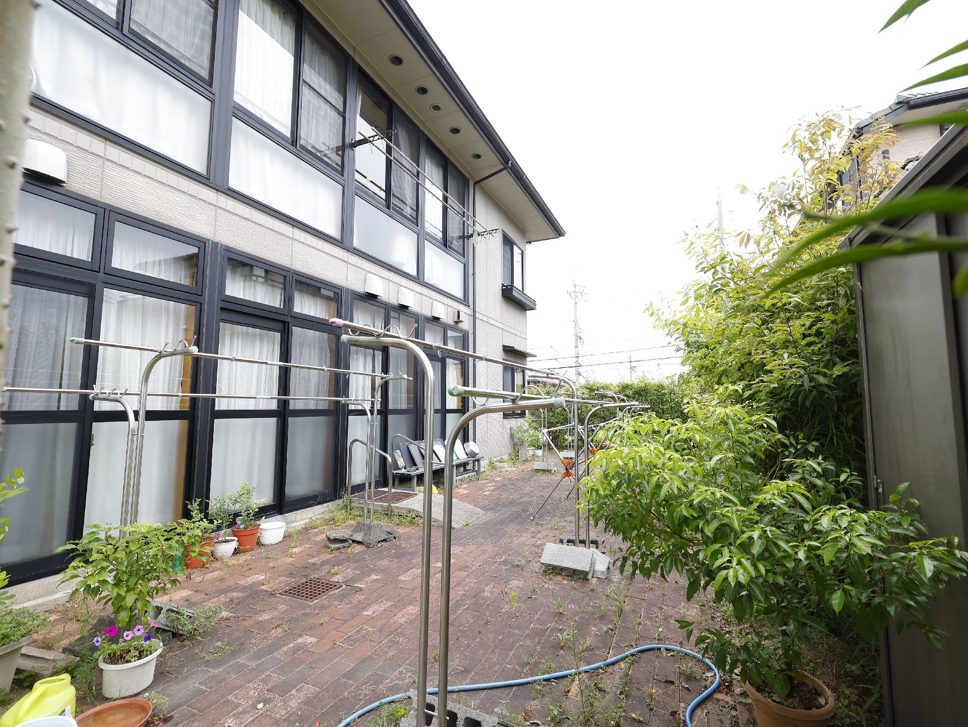 物干し竿がおかれ、花の鉢植えなどが置かれている施設の中庭