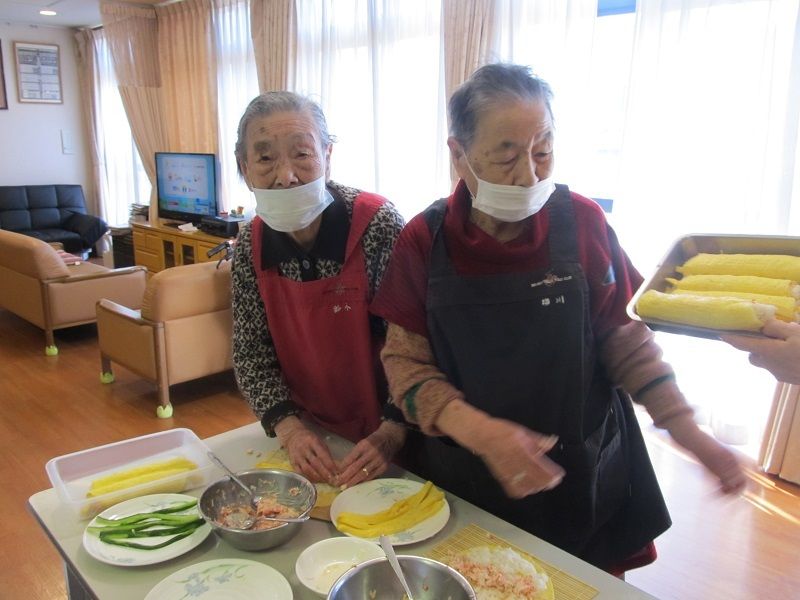 ご入居者様が手巻き寿司を作る様子。マスクを着用し衛生面も考慮している