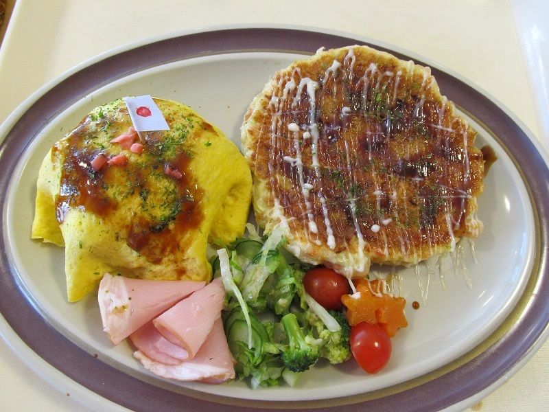 オムライスやお好み焼きなど、さまざまなおかずがワンプレートに盛られたお食事
