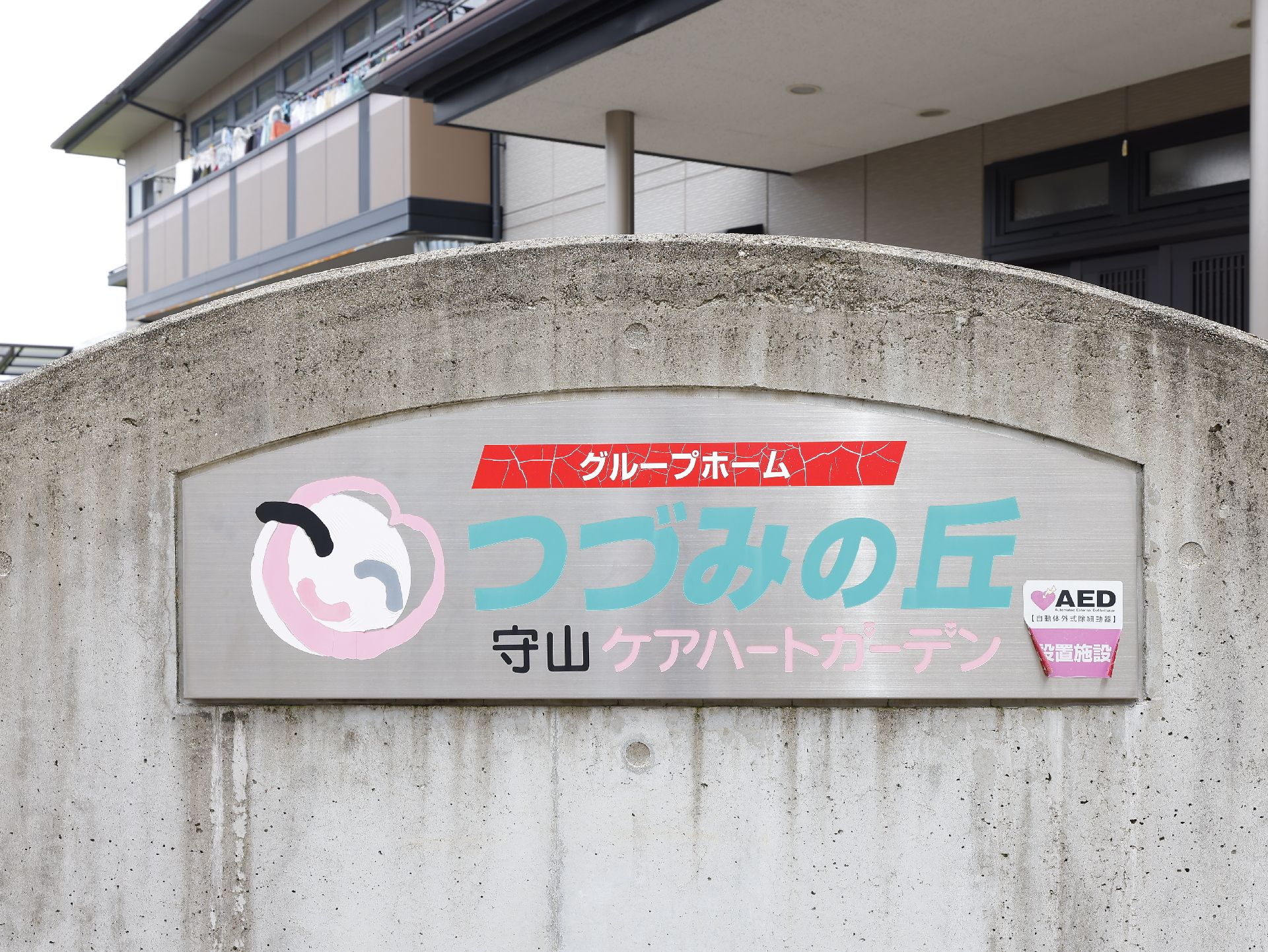 敷地の出入り口に設置され、施設のロゴや名前が記されている看板