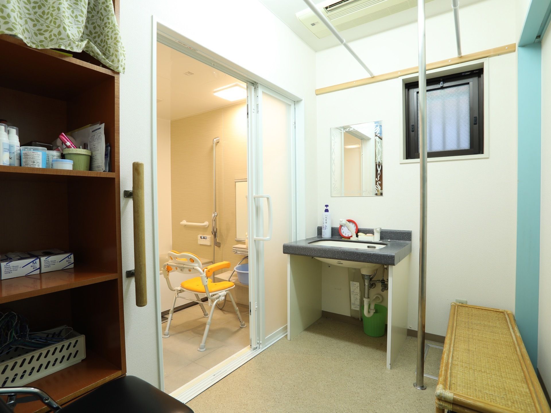 浴室の外には、広々とした脱衣所がある。洗面台が設置されており、そばには大きな収納棚とベンチも置かれている。