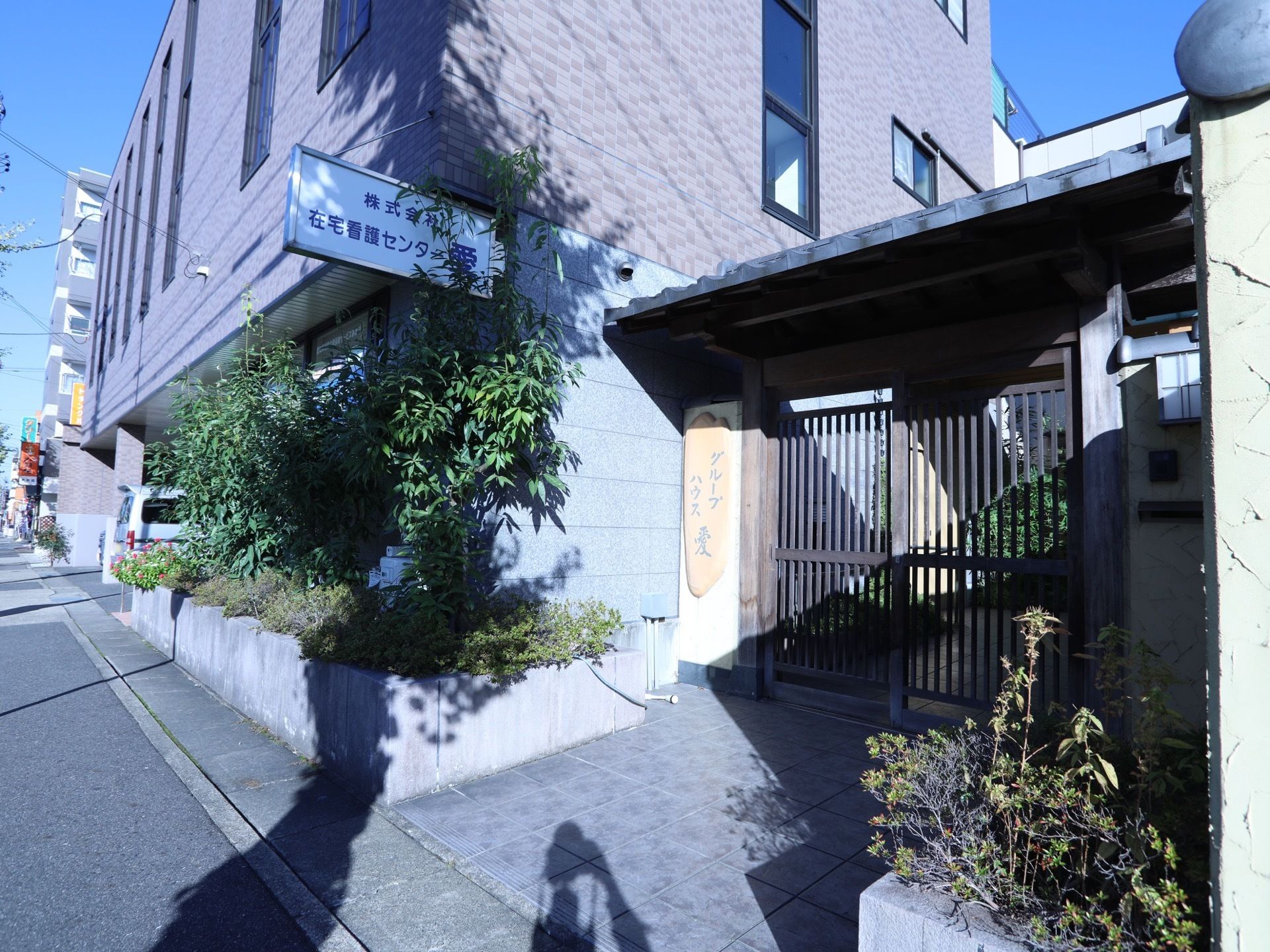 施設の入口には、大きな門が設置されている。両サイドには植物が植えられており、大きな表札も取りつけられている。