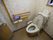 温水洗浄便座付きのトイレが備えられている。トイレの横の壁には手すりが設置され、緊急呼出しボタンも取り付けられているのが見える。