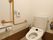 手すりが設置されているトイレである。全体がアイボリーでまとめられており、インテリアに統一感がある。緊急時呼び出しボタンが備わっている。