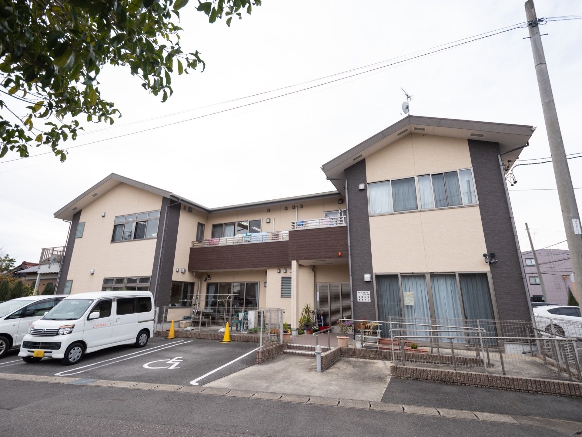 ２階建ての施設で、クリーム色と茶色２色使いの壁材を持つ外観である。玄関横にはテラスと花壇があり、テラスやベランダには洗濯物が干されている。