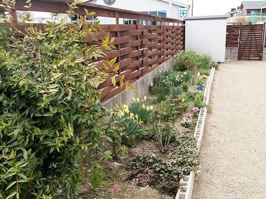 花や草木が植えられた花壇は舗装されていない土のスペースとブロックで仕切られている。