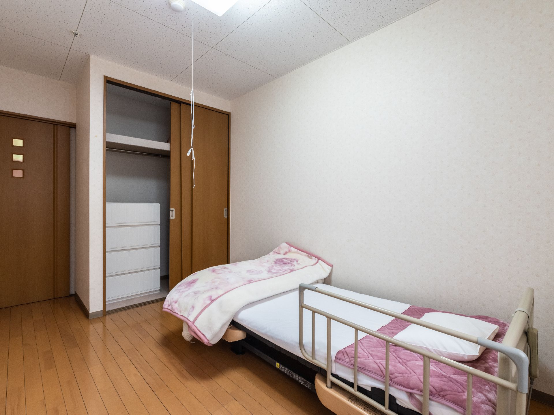 窓から日差しが入り、介護ベッドが置かれている居室