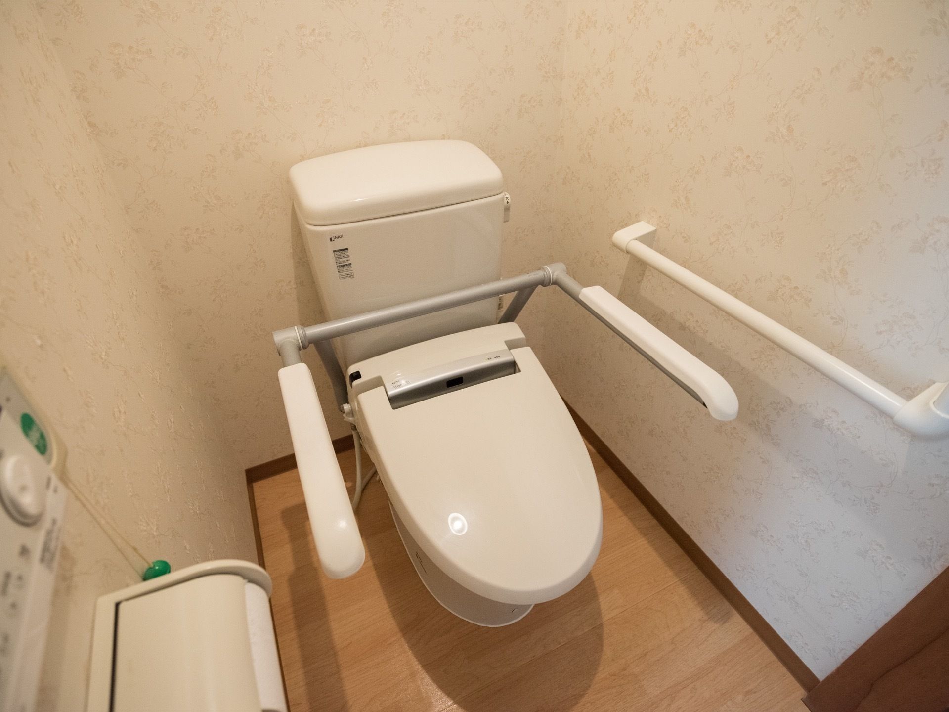 白を基調とした清潔感のあるトイレである。壁には、ナースコールが設置されているほか、複数の手すりもある。