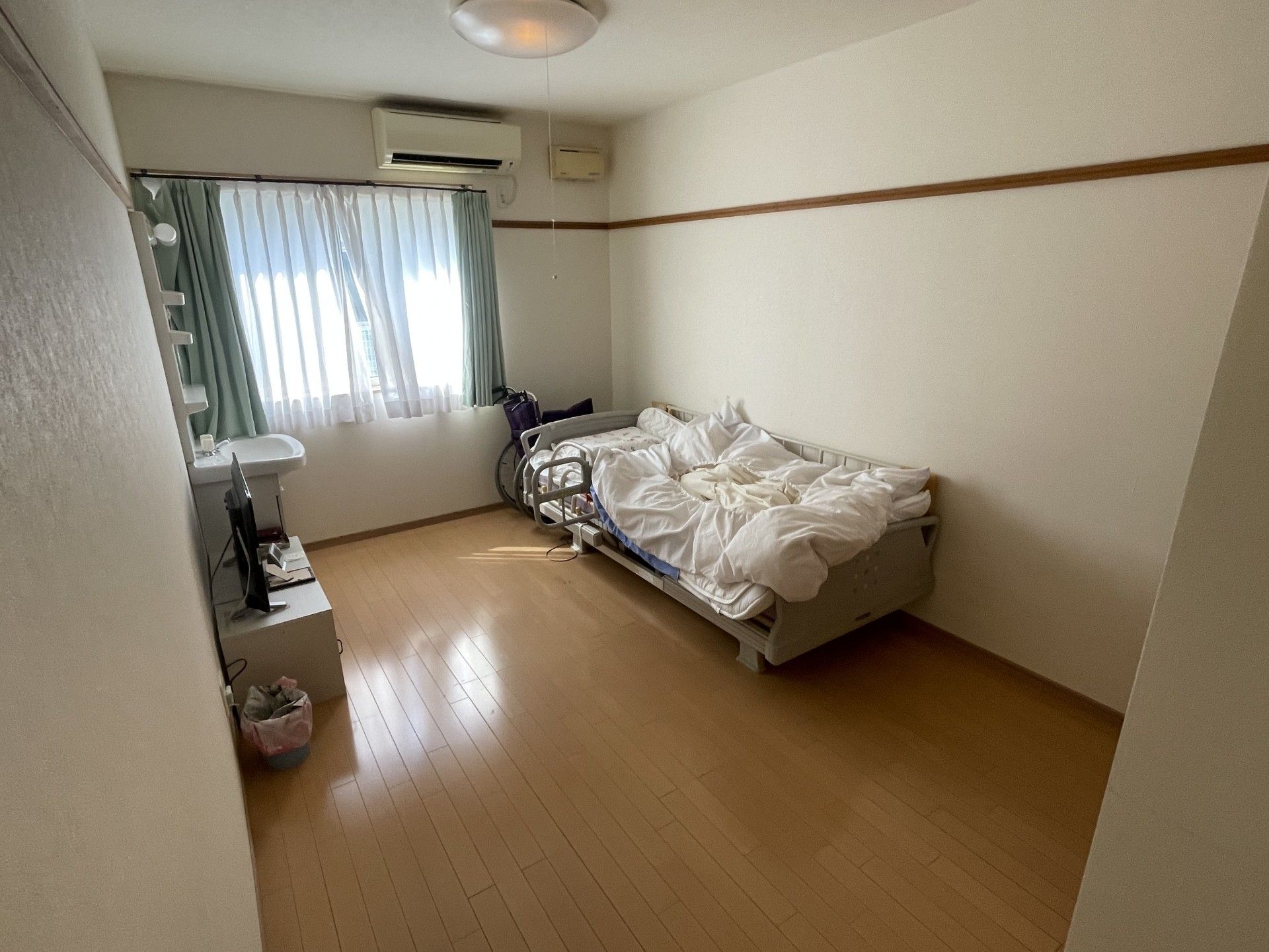 まっすぐな廊下の両サイドに居室が並び、スライド式のドアが設置されている。表札や暖簾もある。