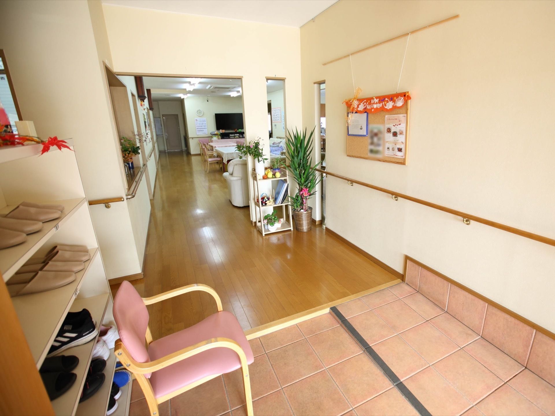 下駄箱の置かれた玄関がある。壁には手すりが設置され、コルクボードが掛けられている。正面は談話室へと繋がっている。