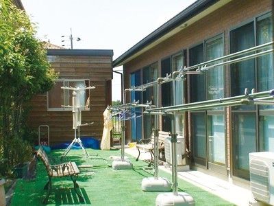 芝生が敷き詰められている小さな中庭の様子。右側に建物と物干し台