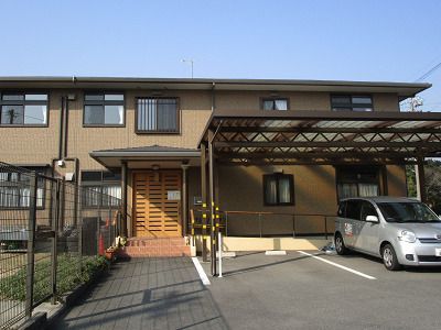 赤いロープを引っ張っている高齢女性をブルーのユニフォームを着た男性スタッフがサポートしている。