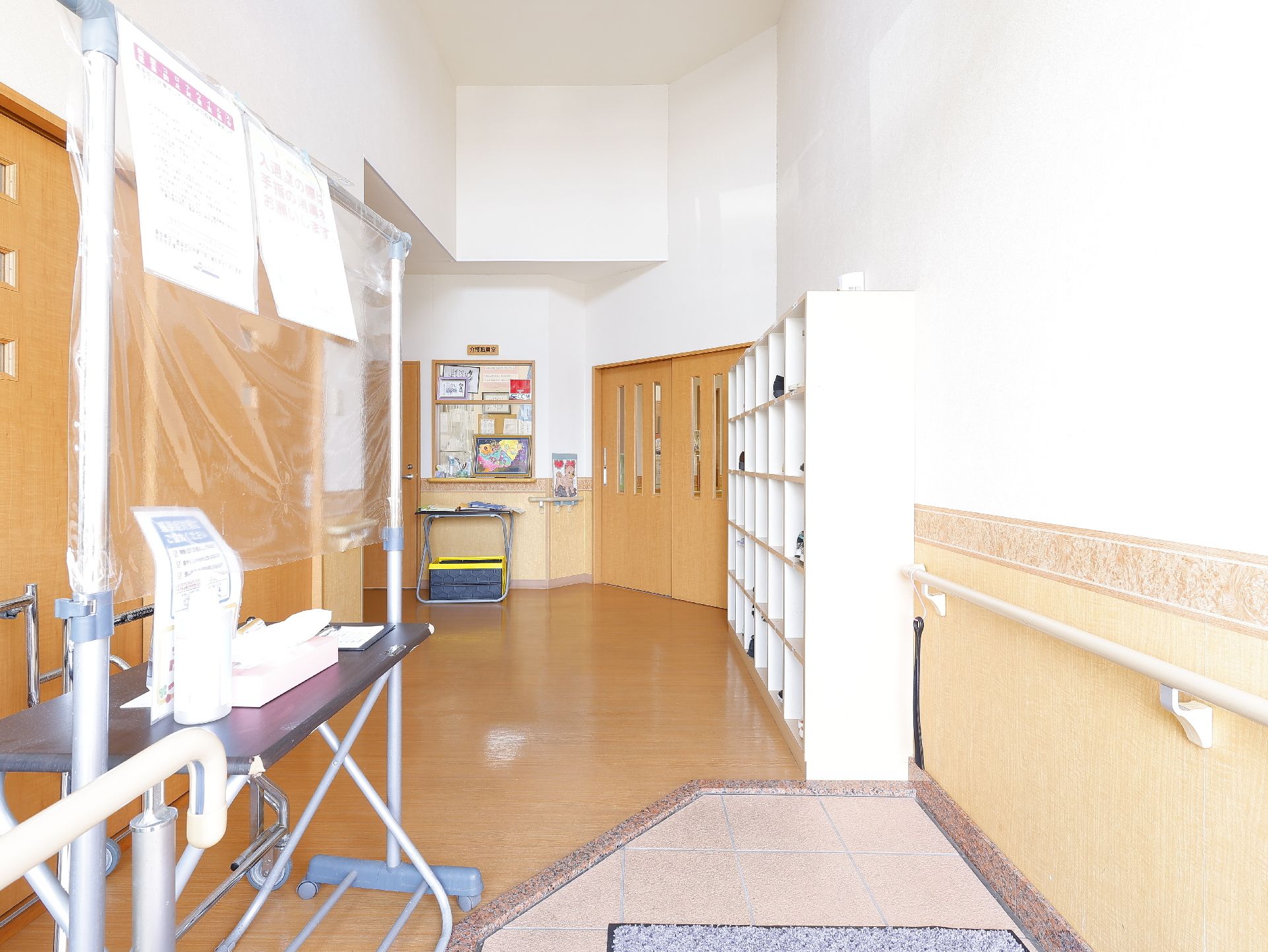 カメラに向かって笑顔を見せるスタッフと高齢者の女性。施設での何気ない一場面の様子