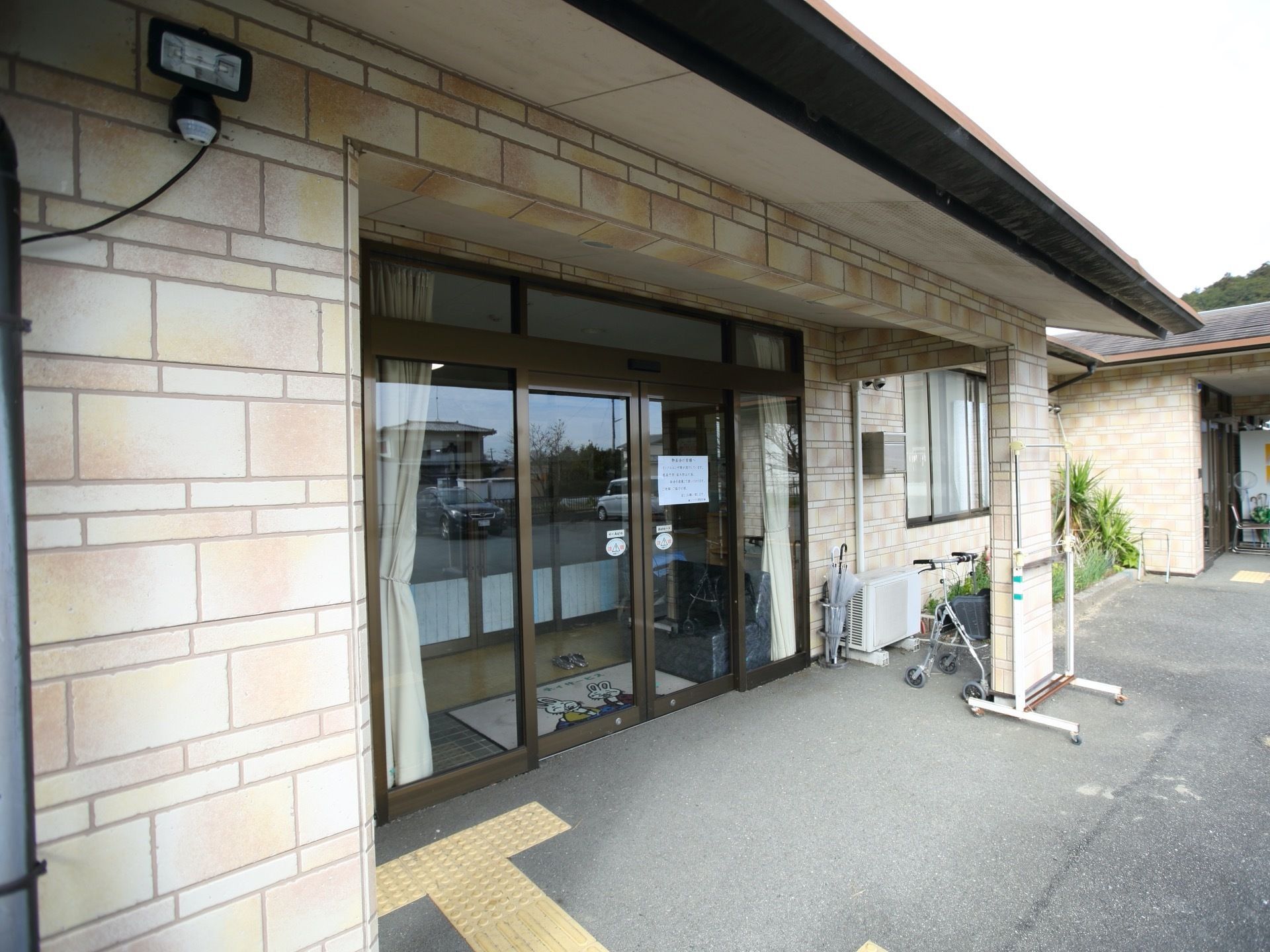 施設入口にはひさしが完備され、イエロー色の点字ブロックが設けられている。両開きの自動扉が設置されている。