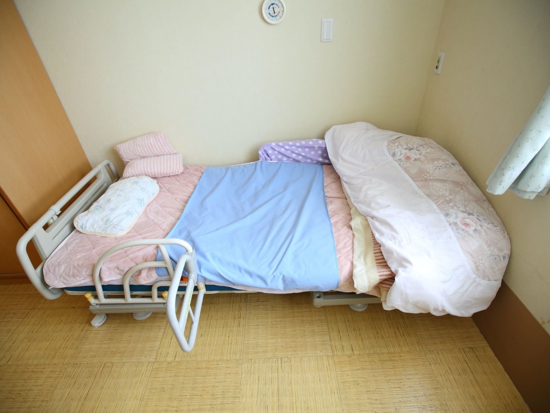 介助バーが装着された介護用ベッドが設置されている。昇降やリクライニングがリモコン操作で簡単にできる。
